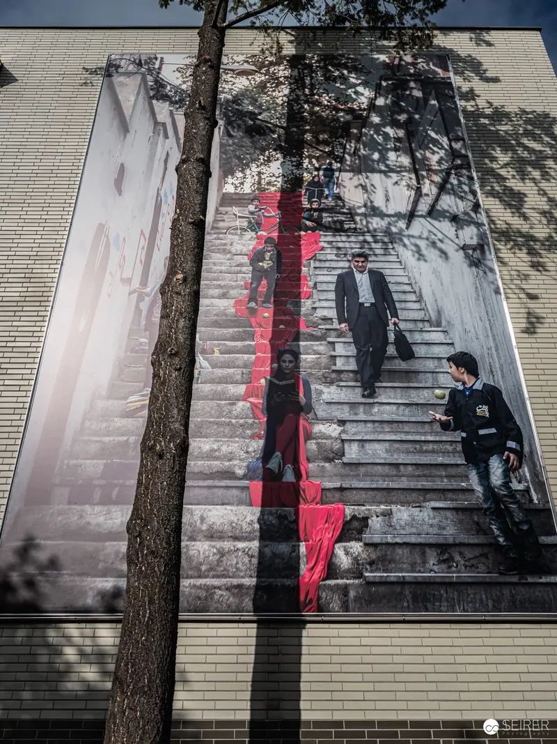 Shadowed Figures on Urban Staircase during Ansichten Festival Orient Exhibit