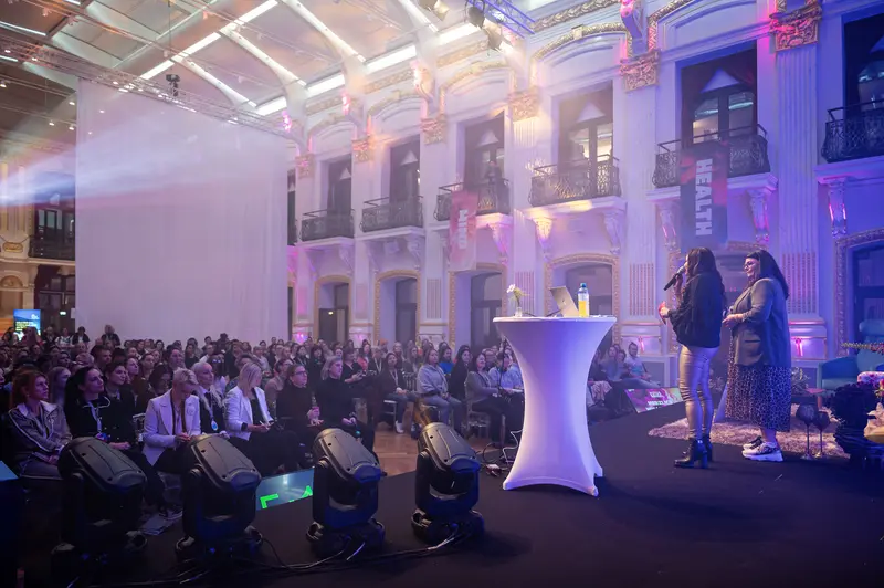 Health & Mind Festival Speakers Illuminated on Dramatic Purple-Lit Stage