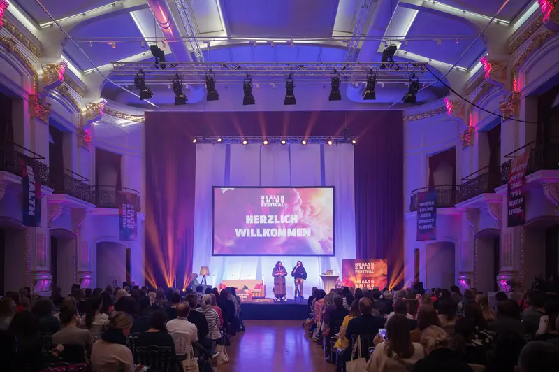 Herzlich Willkommen: Health & Mind Festival Stage in Vibrant Purple Illumination