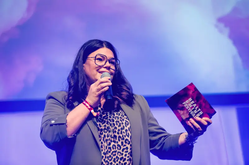 Health & Mind Festival Speaker Presents Book on Purple-Hued Stage