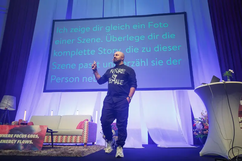 Speaker Presenting at Health & Mind Festival with Projected German Text