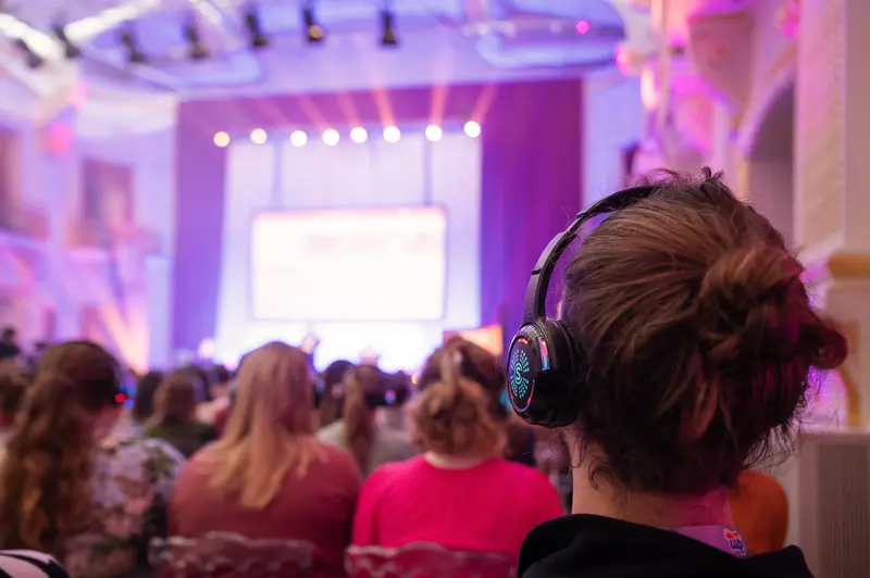 Health & Mind Festival: Attendee in Headphones Observes Presentation Stage