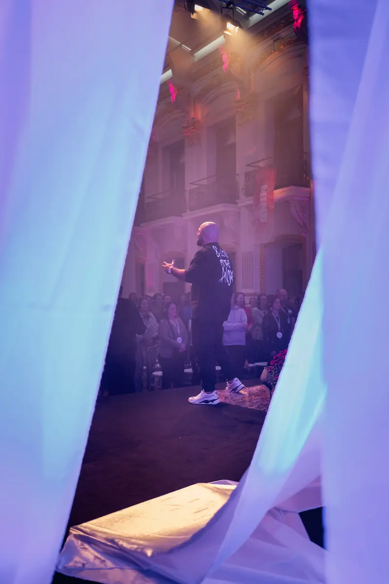 Health & Mind Festival: Performer Silhouetted Through Translucent Stage Curtain