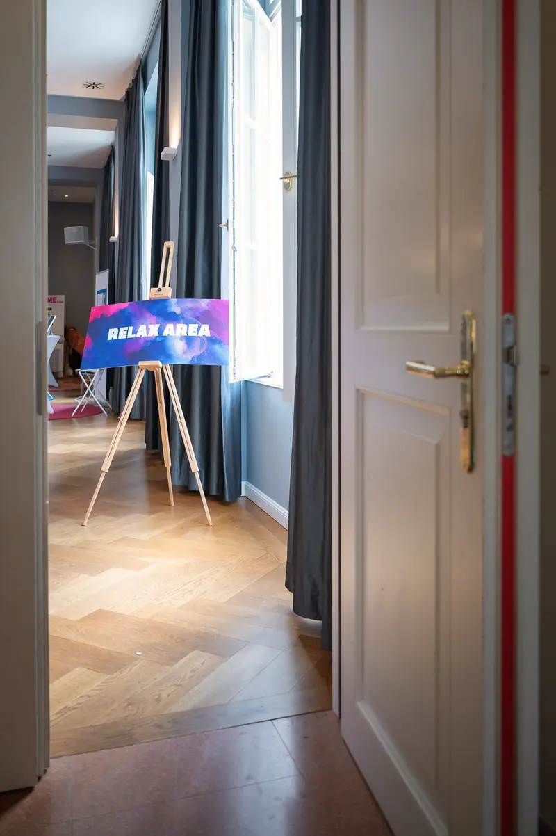 Relay Area Sign on Tripod in Minimalist Interior with Herringbone Wooden Floor
