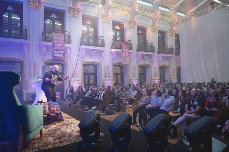 Health & Mind Festival: Presenter Addressing Large Audience in Ornate Illuminated Venue