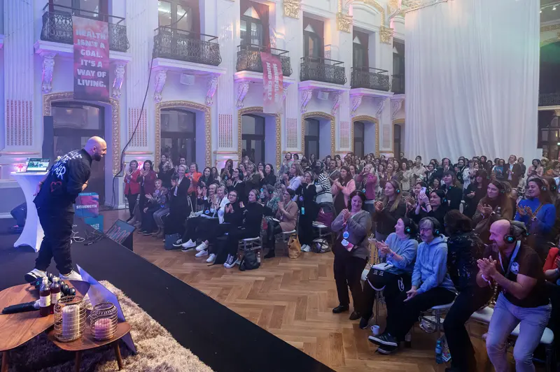 Health & Mind Festival: Speaker Addressing Attentive Audience in Elegant Architectural Space