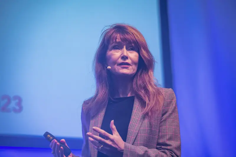 Health & Mind Festival Speaker Delivers Presentation in Blue-Toned Stage Environment