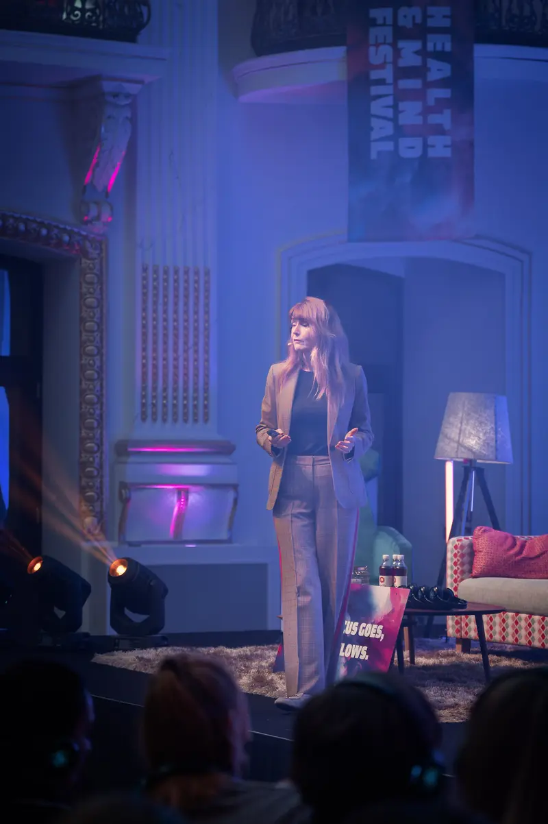 Health & Mind Festival Speaker Illuminated on Atmospheric Stage with Pink and Blue Lighting