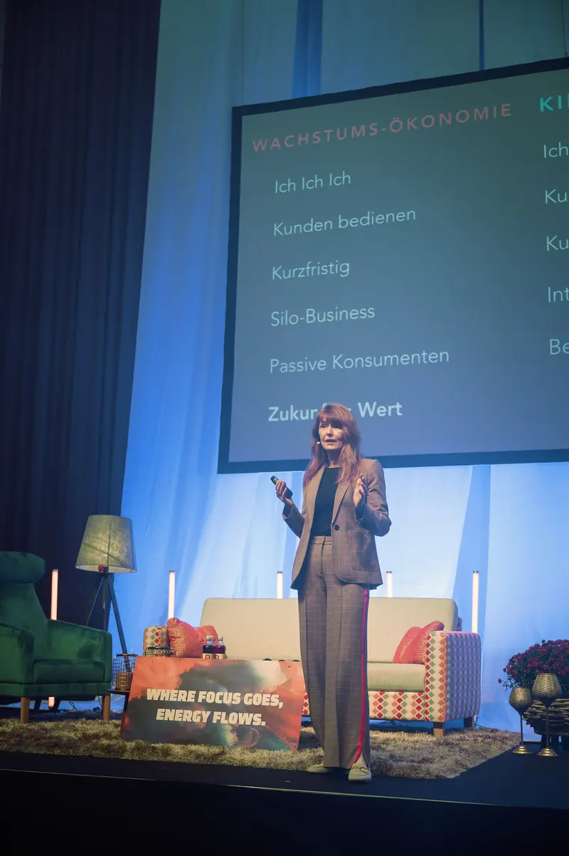 Woman Presenter Discussing Growth Economics at Health & Mind Festival