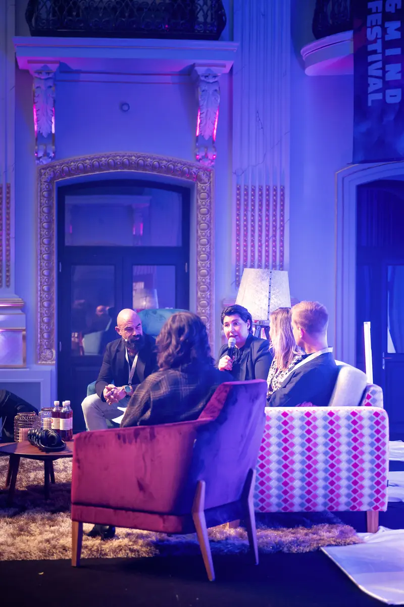 Health & Mind Festival Participants Engaged in Intimate Conversation Under Blue Illumination