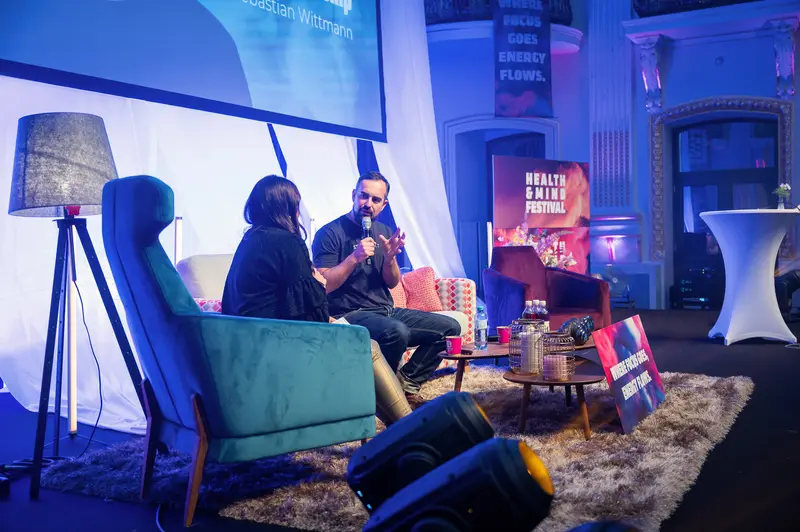 Health & Mind Festival: Intimate Stage Discussion in Blue-Tinted Setting