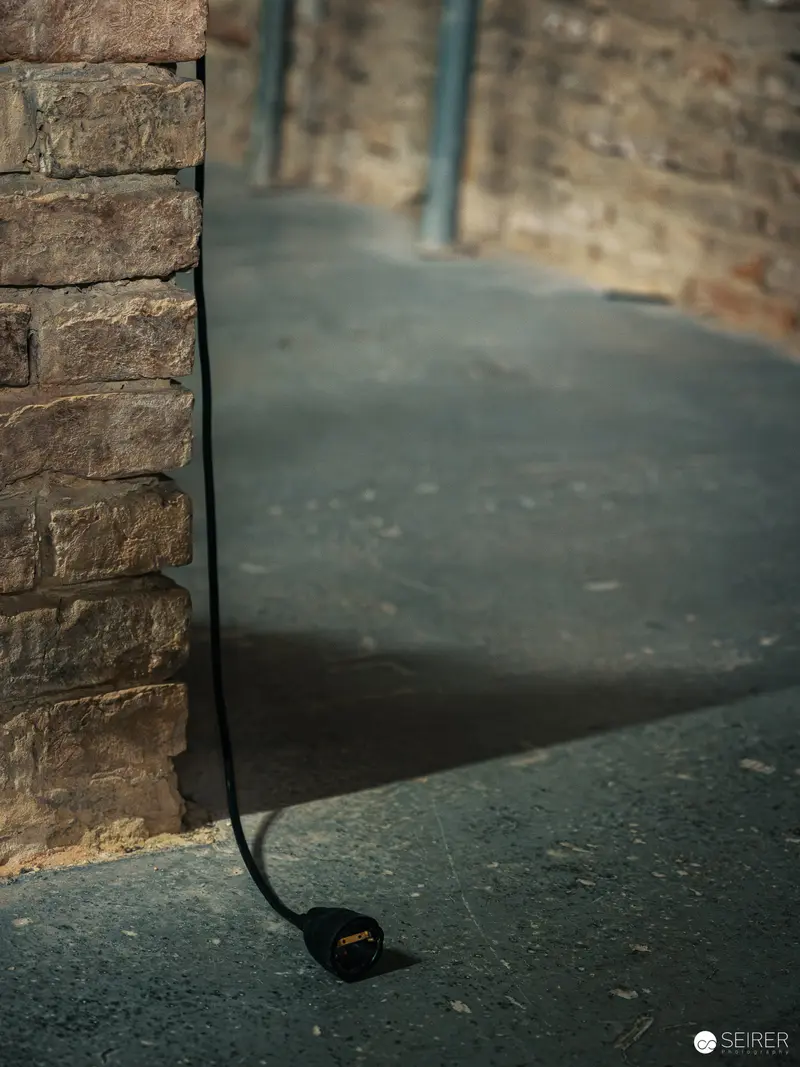 Suspended Microphone Casting Dramatic Shadow Against Stone Wall