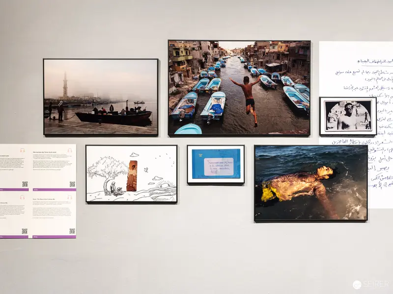 Exhibition Wall Displaying Diverse Photographic Scenes of Maritime and Urban Life