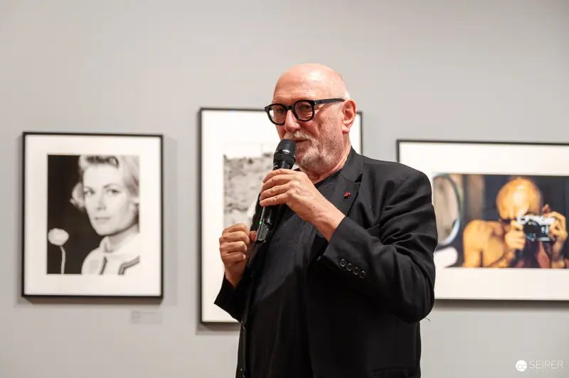 Art Gallery Lecture: Photographer Speaking amid Framed Black and White Portraits