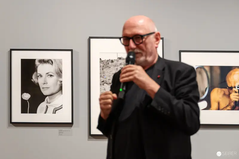 Art Gallery Lecture with Framed Photographic Portraits in Background