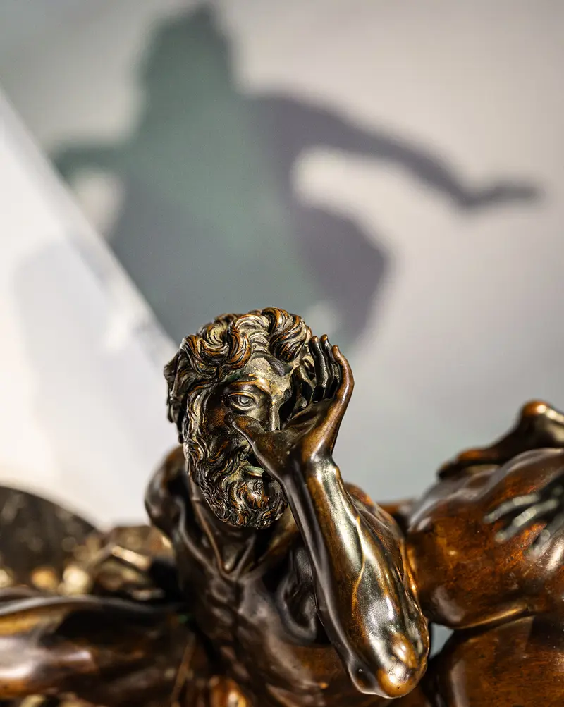 Bronze Sculpture of Contemplative Nude Figure with Dramatic Shadow