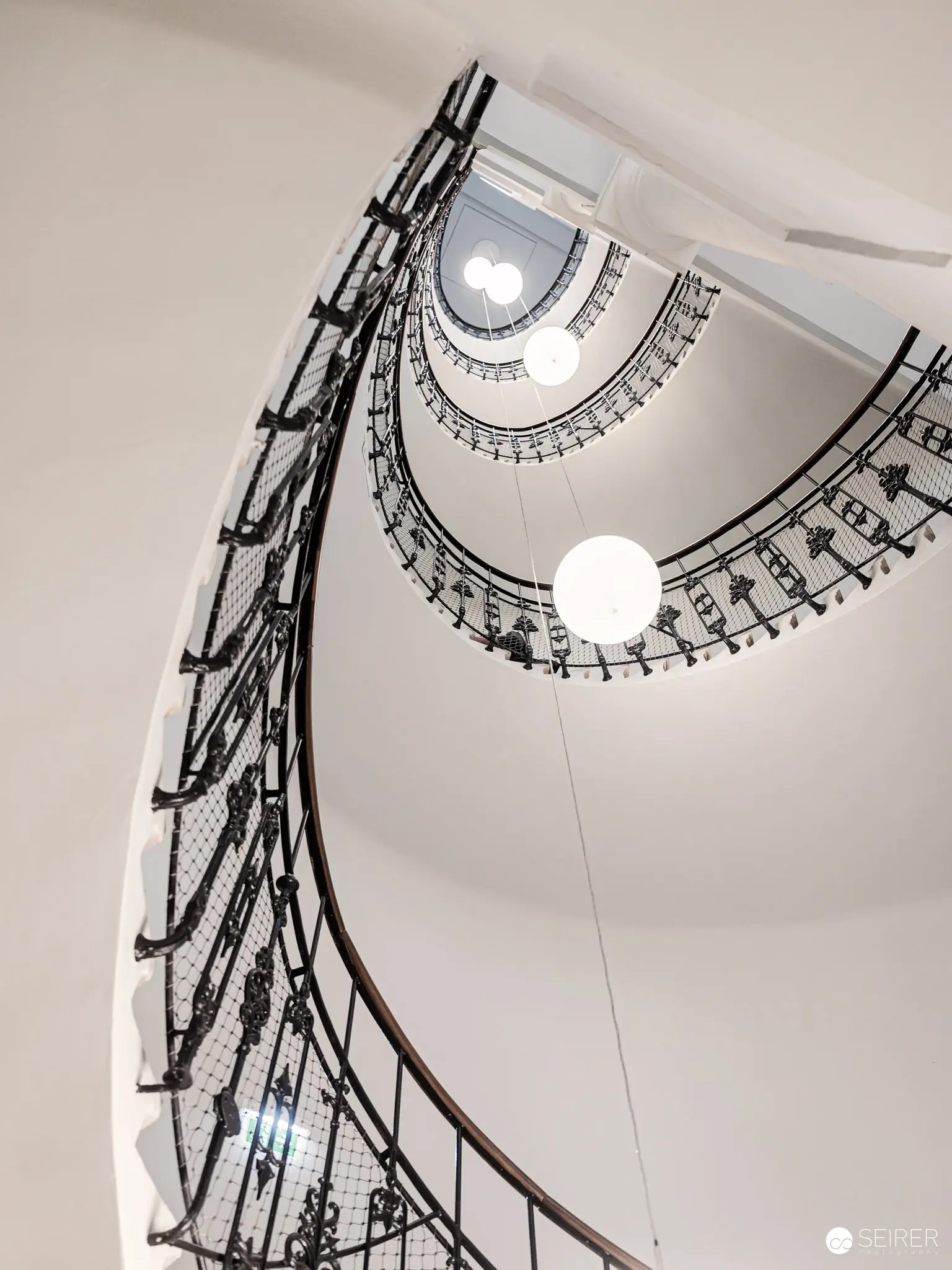 Spiral Staircase: Elegant Architectural Perspective with Ornate Metalwork Railing