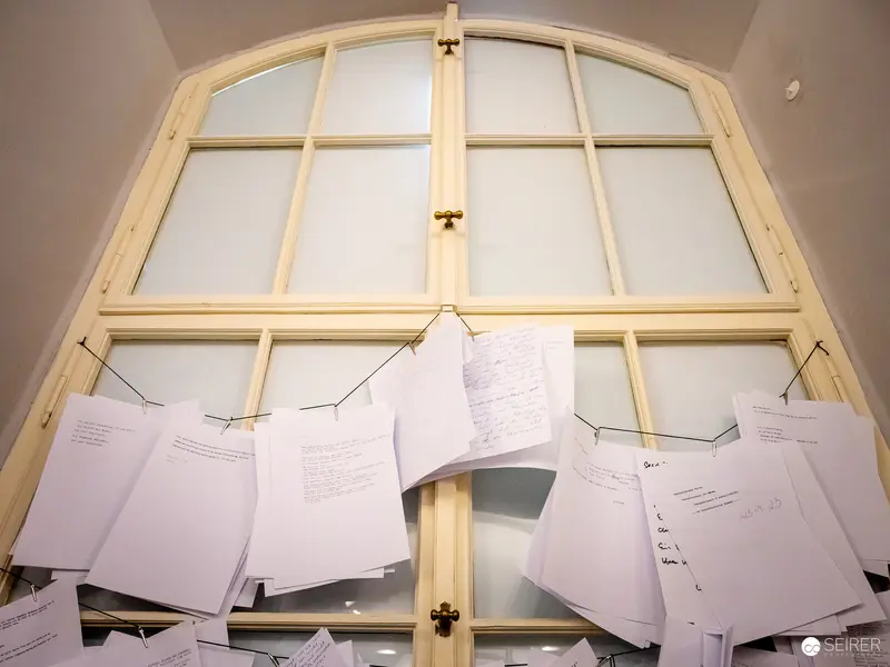 Documents Pinned on Arched Window Frame in Exhibition Space