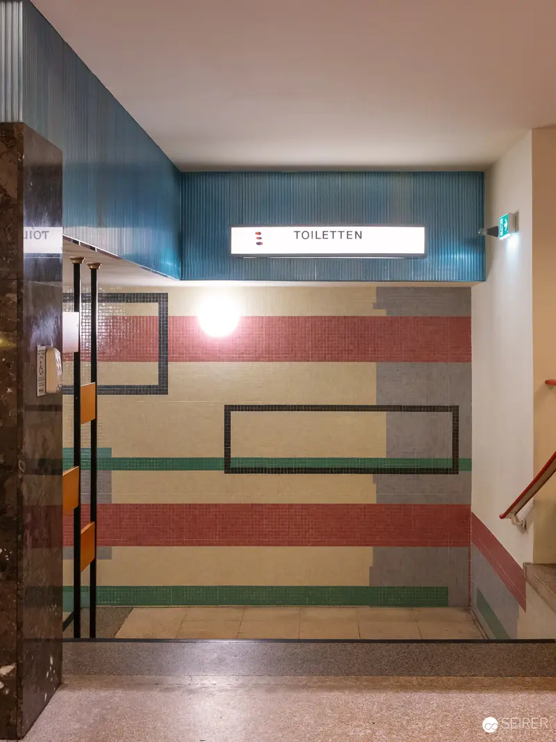 Toiletten Signage with Geometric Color Block Wall Design in Interior Space