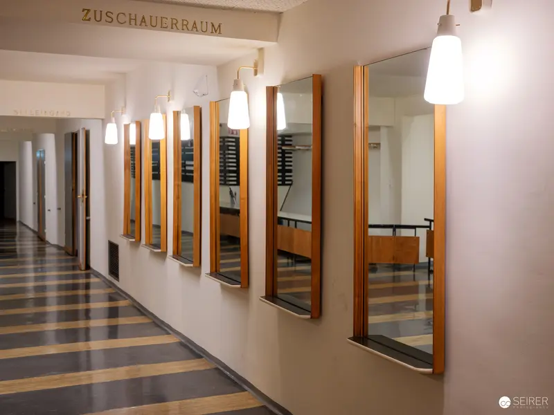 Austere Institutional Corridor with Mirrors and Pendant Lights