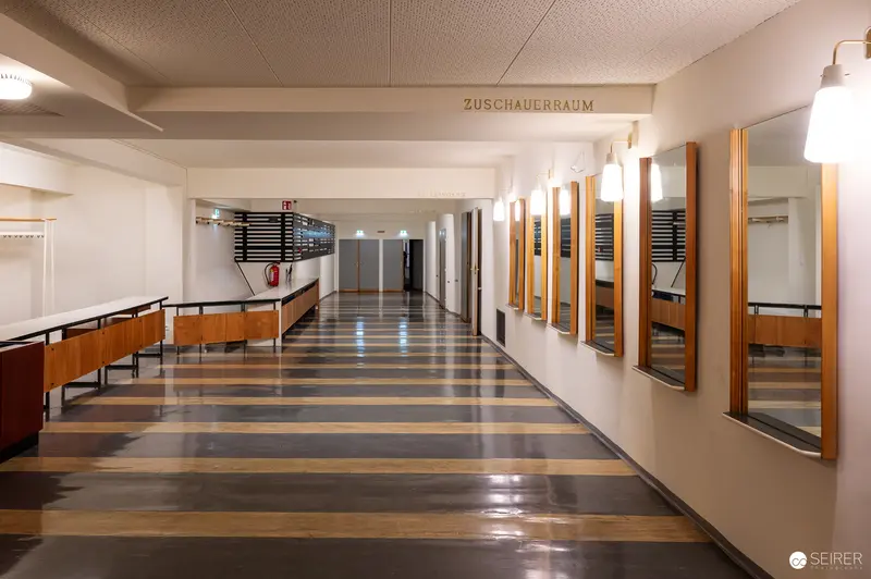 Austere Corridor in Modernist Interior with Geometric Flooring and Mirrors