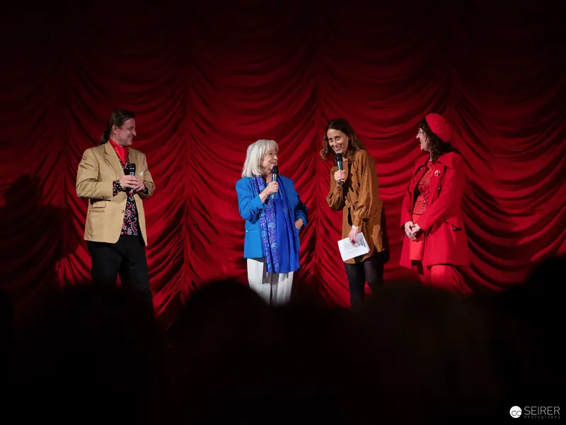 "Ingeborg Bachmann Hommage: Four Speakers on Red Draped Stage"