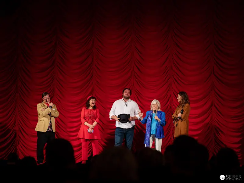 "Ingeborg Bachmann Hommage: Five Performers on Red Draped Stage"