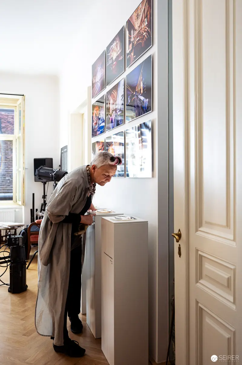 Archival Workspace: Elderly Person Examining Documents Near Photography Display