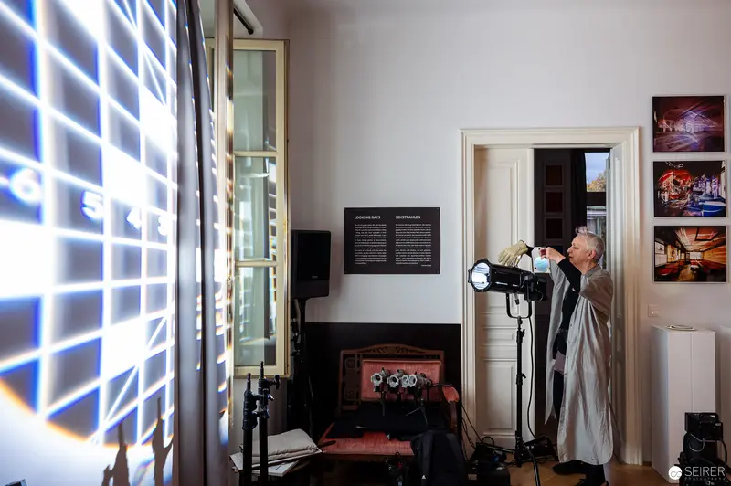 Photographer Adjusting Light Grid in Atmospheric Studio Setting