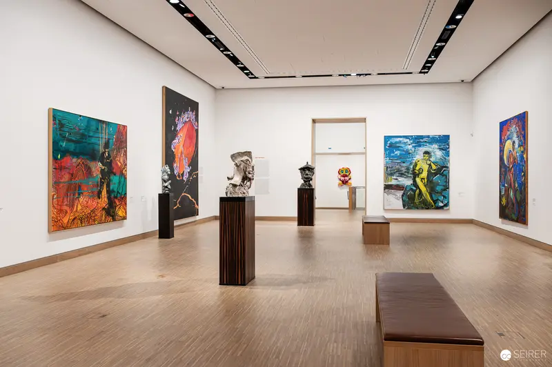 Large-format paintings and pedestal-mounted sculptures fill an exhibition room of "Österreich – Deutschland. Malerei 1970–2020" at Albertina Modern in Vienna, Austria, in October 2023. The exhibition surveyed five decades of Austrian and German painting, shown at Albertina Modern in the Künstlerhaus building on Karlsplatz.