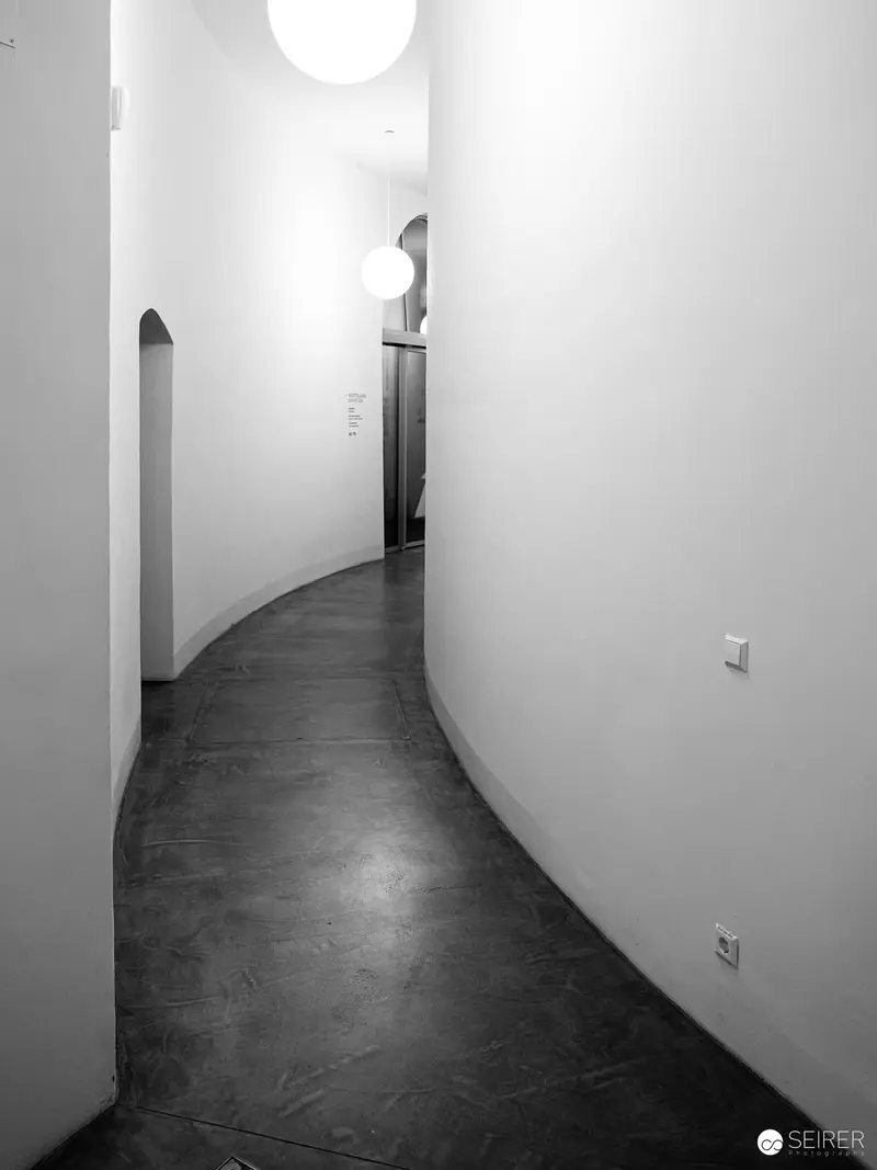 Curved Hallway with Arched Doorway in Monochromatic Architectural Study
