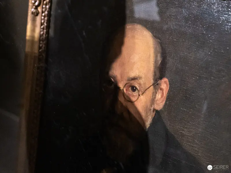 Pensive Elder with Round Spectacles in Shadowy Portrait