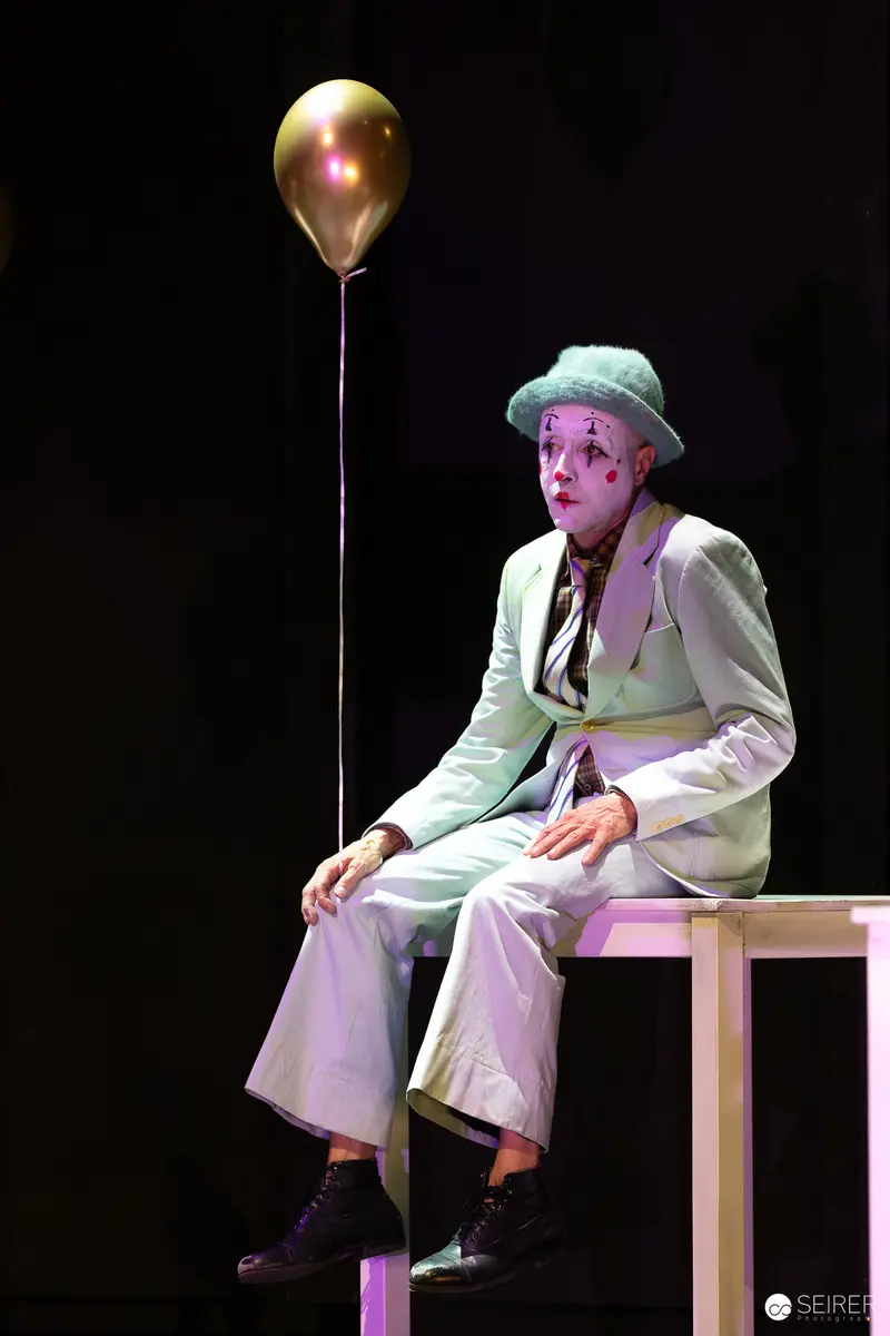 Actor in clown makeup with gold balloon, "Bis nächsten Freitag", Theater in der Josefstadt