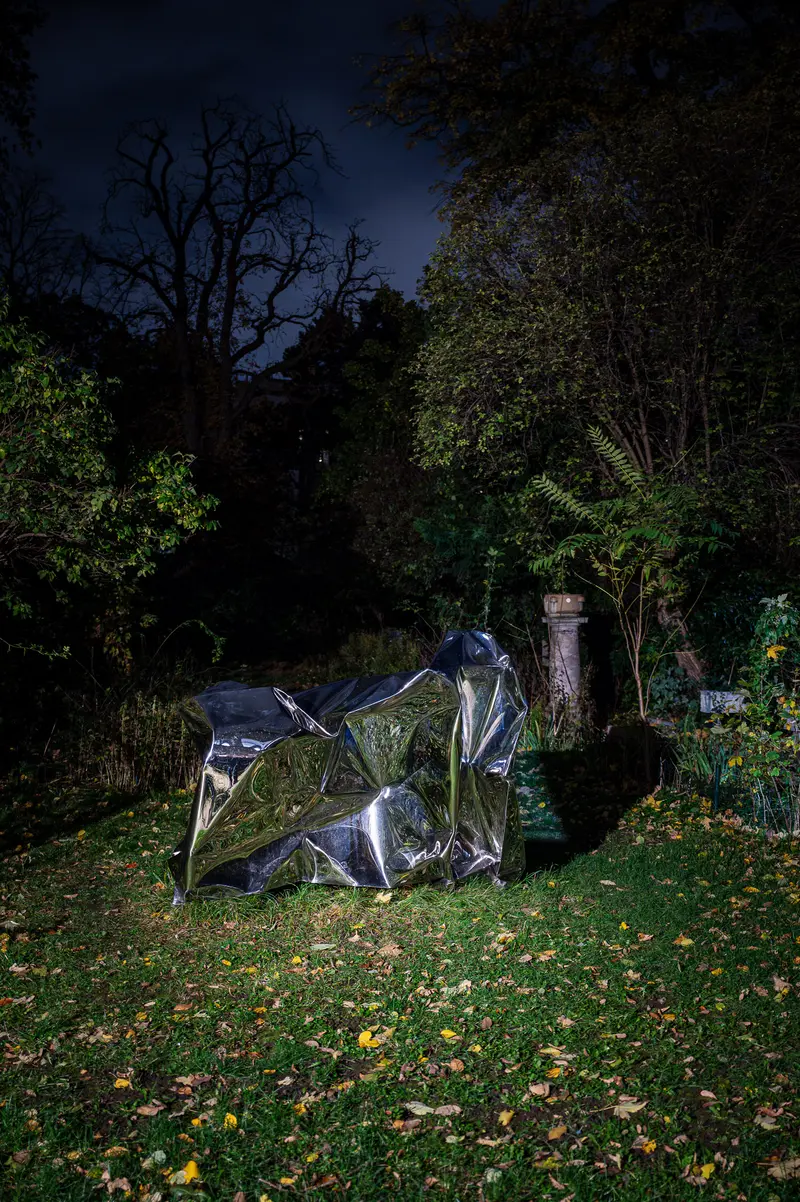 Nocturnal Sculptural Form: Illuminated Metallic Object in Darkened Woodland Setting