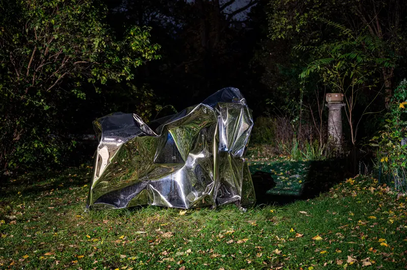 Nocturnal Geometric Sculpture: Crumpled Reflective Material in Woodland Setting