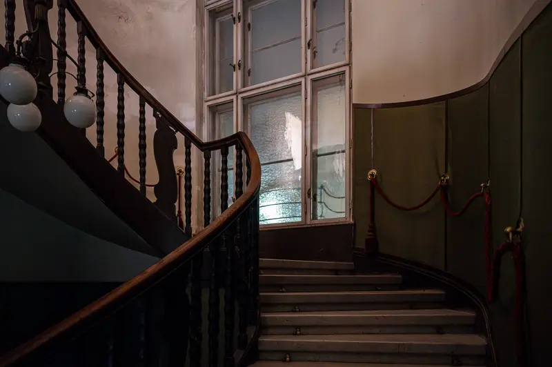 Vintage Interior Staircase with Curved Banister and Globe Lighting