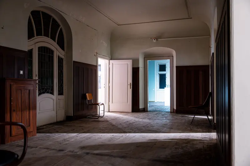 Abandoned Interior with Arched Doorways and Wooden Paneling