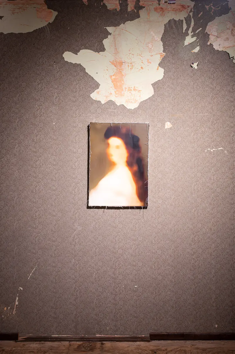 Luminous Portrait Suspended on Weathered Wall with Peeling Texture