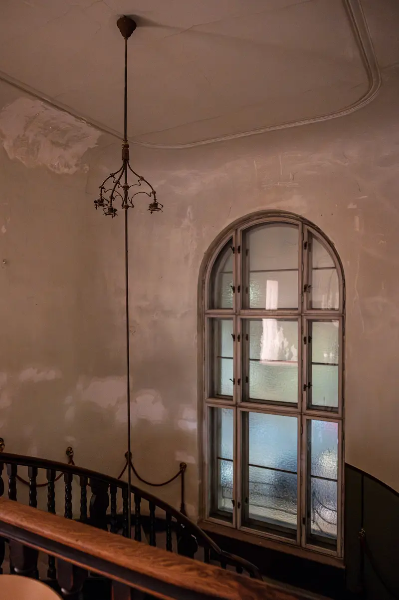Arched Window and Hanging Lamp in Vintage Interior Stairwell