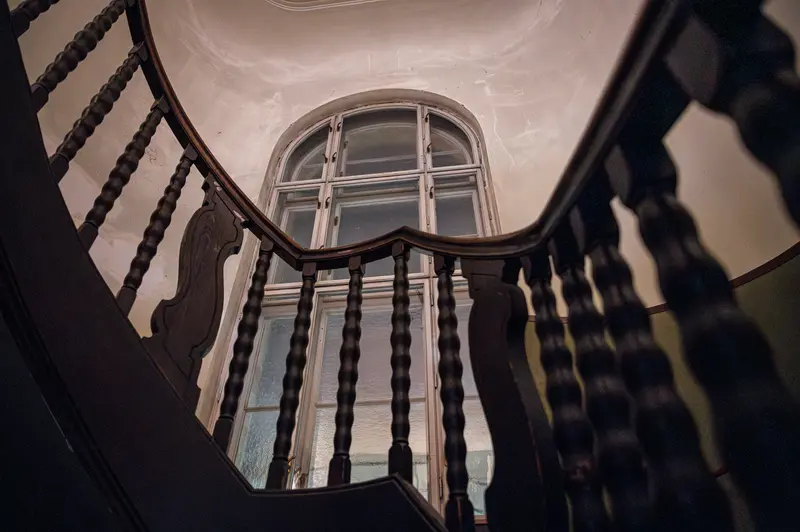Interior Staircase with Arched Window, Spiral Balusters Framing Architectural Perspective