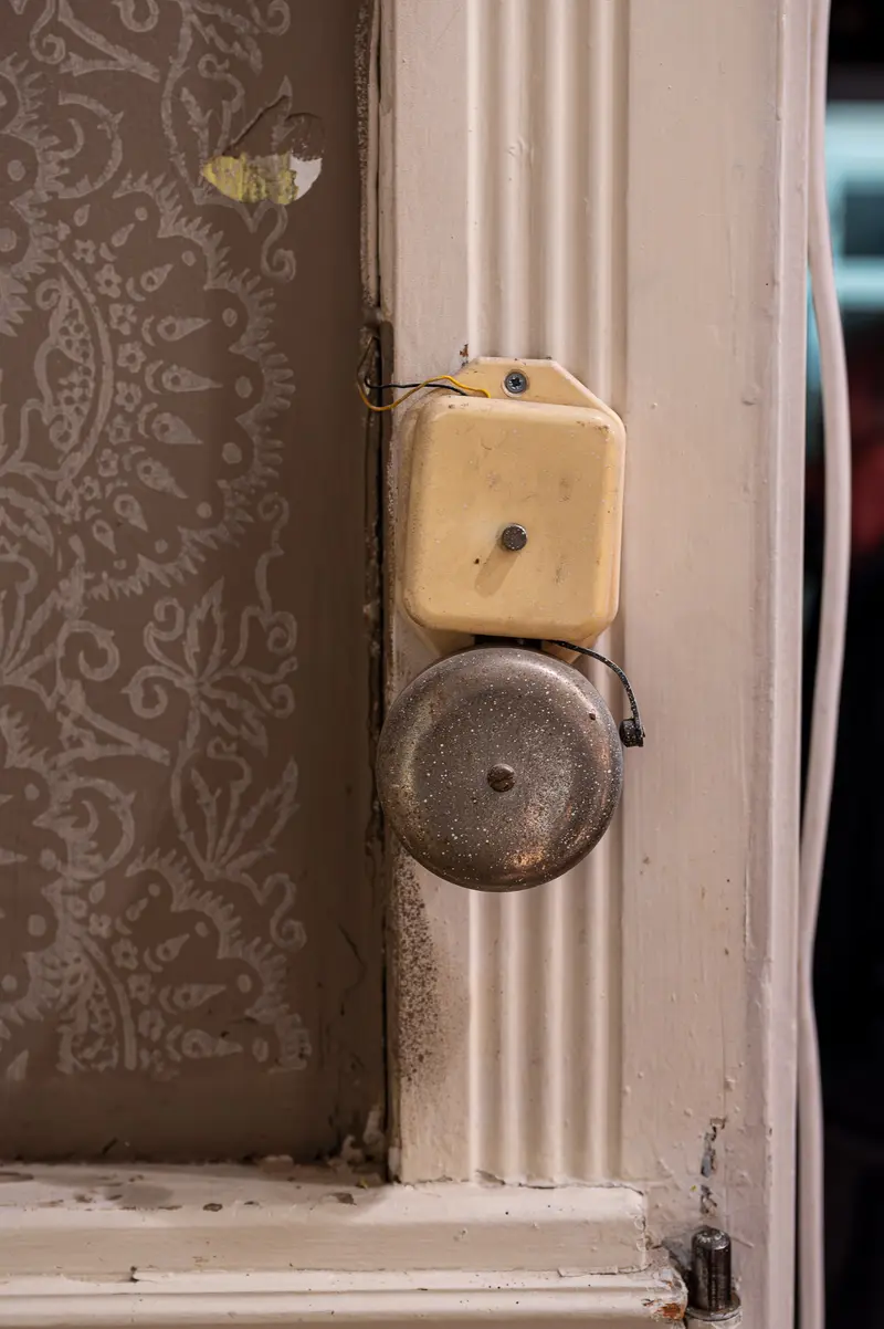 Vintage Electrical Switch and Bell on Ornate Wallpapered Interior Wall