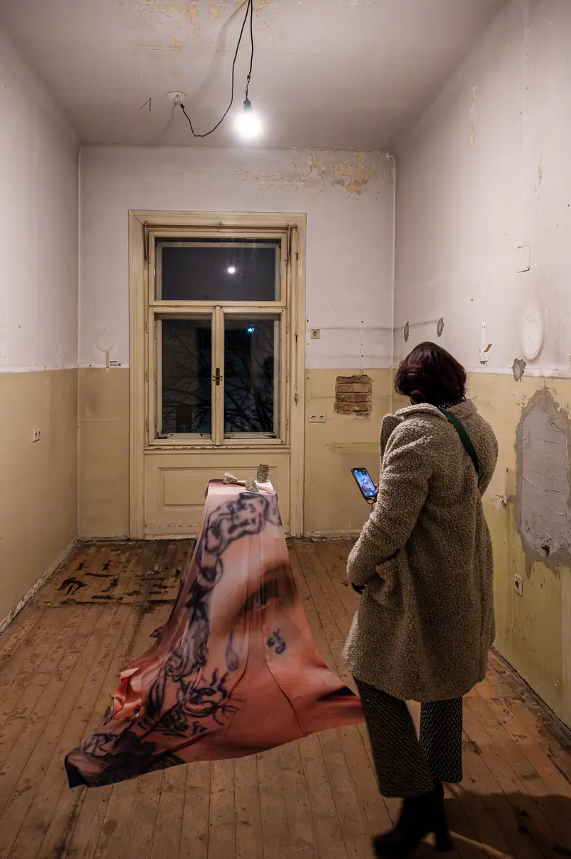 Solitary Figure in Worn Interior Contemplating Digital Device by Window