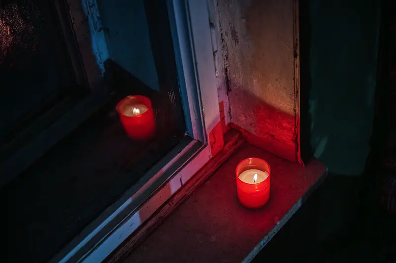 Crimson Candles Illuminating Shadowy Window Frame at Twilight
