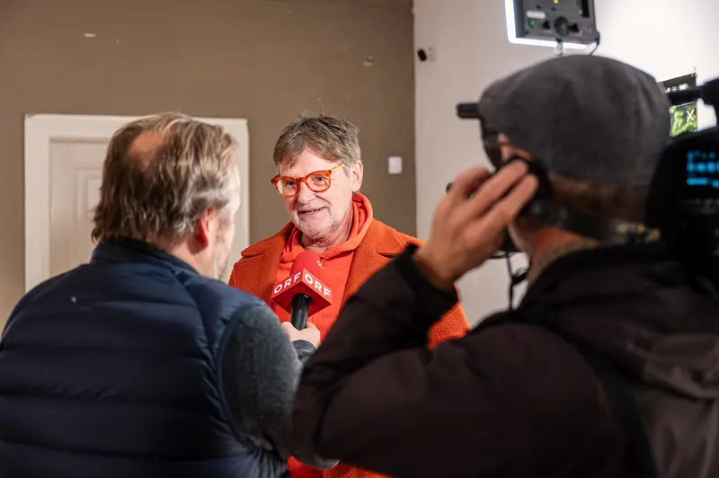 Media Interview with Person in Red Sweater and Red Glasses