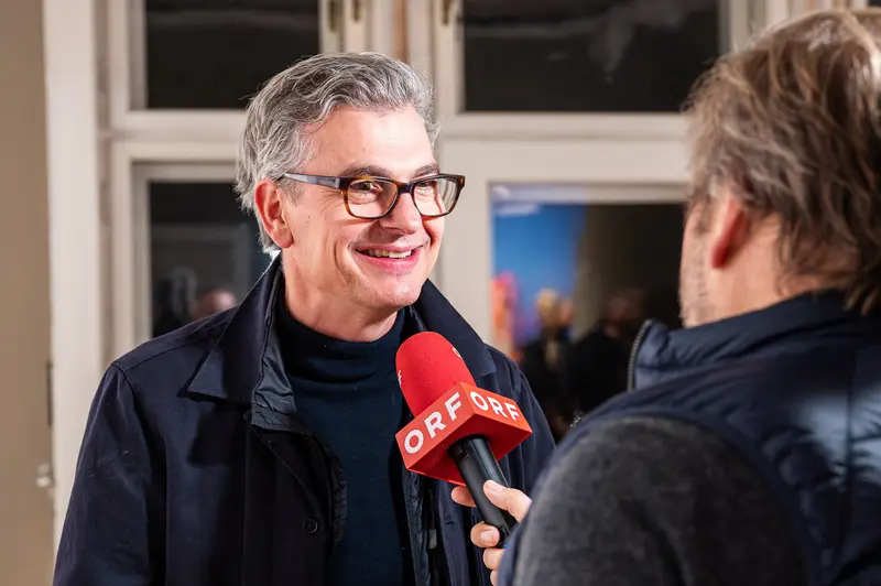 ORF Interview with Smiling Glasses-Wearing Man in Black Jacket
