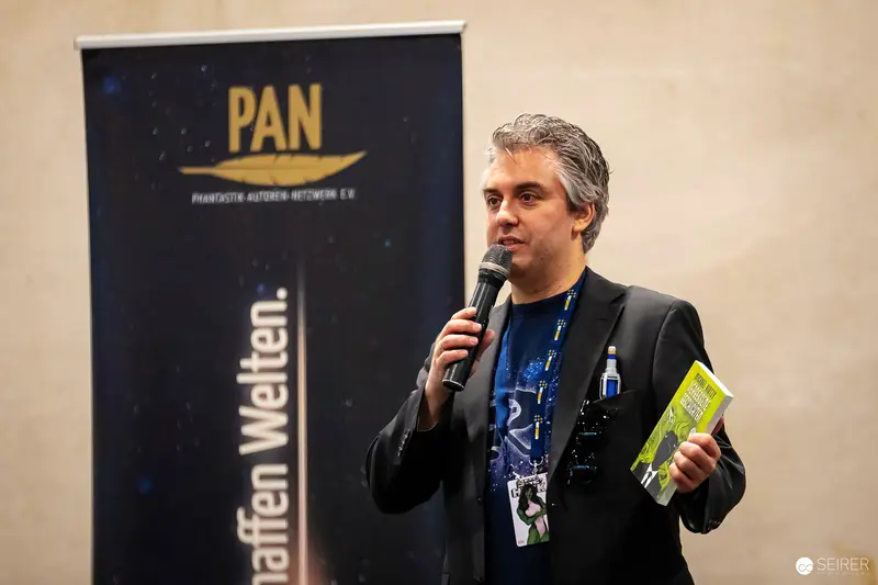 PAN Event Speaker Presents at Conference with Microphone and Materials