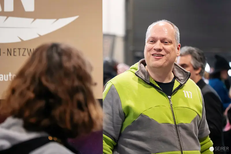 Vienna ComicCon 2023: Participant in Bright Safety Vest Smiling at Event