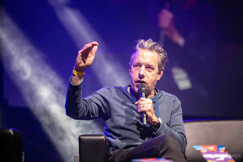 Performance Speaker Gesturing Dynamically During Vienna ComicCon 2023 Panel Discussion
