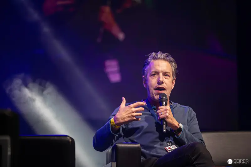 Speaker Gesturing Passionately During Panel Discussion at Vienna ComicCon 2023