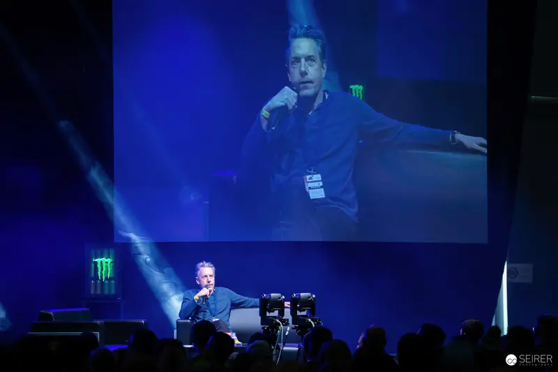 Presenter Speaking at Large-Scale Event with Dynamic Blue Stage Lighting